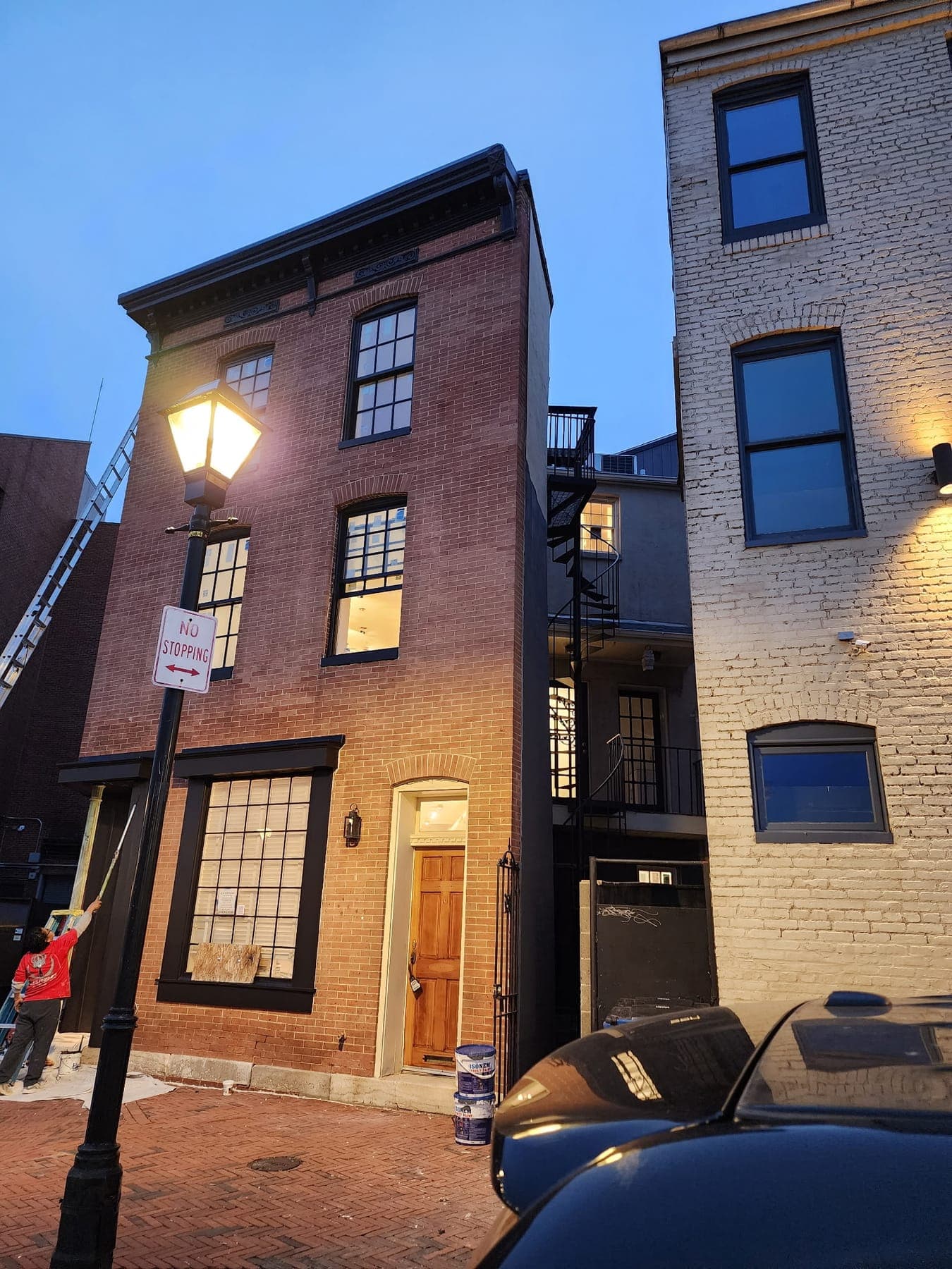 Baltimore brick rowhouse with trim and cornice painted black by Elite Finishes
